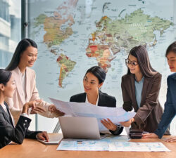 Diverse businesswomen discussing a project with map in front of them